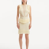 "Model wearing the Diani Yellow Dress from the back, highlighting the low back design with gleaming golden clasps and the delicate mesh knit fabric."