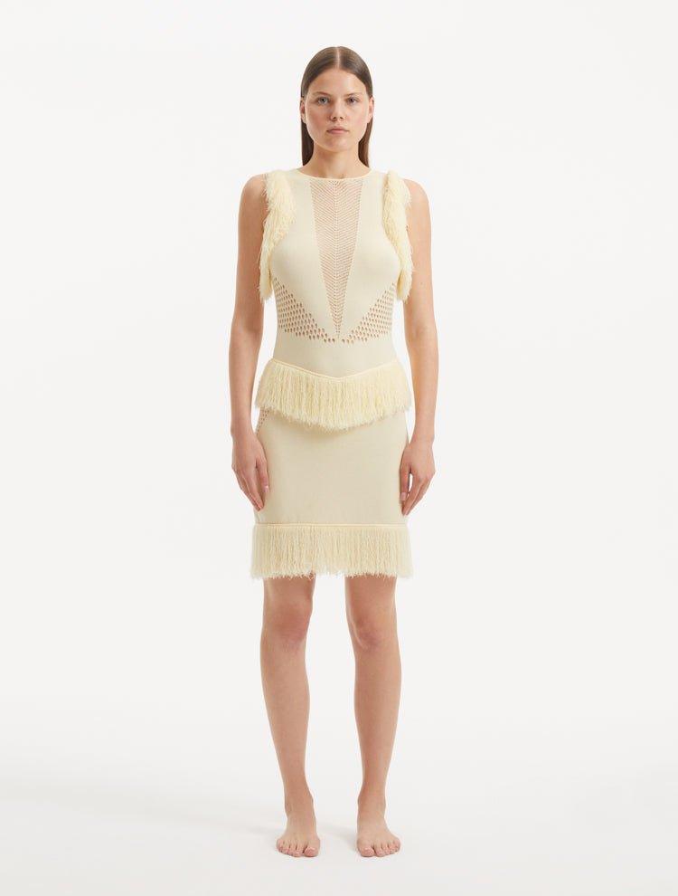 "Model wearing the Diani Yellow Dress from the back, highlighting the low back design with gleaming golden clasps and the delicate mesh knit fabric."