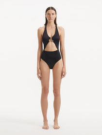 Model wearing the Dwyn Black Swimsuit, highlighting the tie-neck design and gold sculpted accessory.