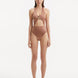 Model wearing the Dwyn Brown Swimsuit, highlighting the tie-neck design and gold sculpted accessory.