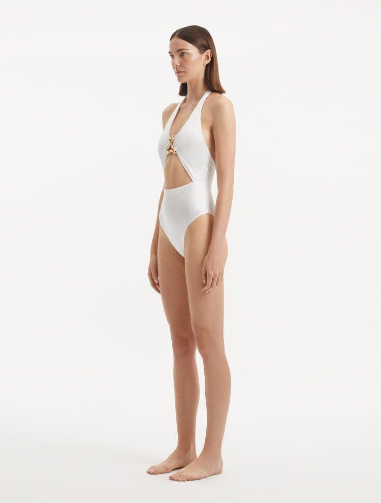 Side view of the Dwyn White Swimsuit, emphasizing the unique cut-out detail and elegant silhouette.