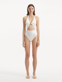 Model wearing the Dwyn White Swimsuit, highlighting the tie-neck design and gold sculpted accessory.