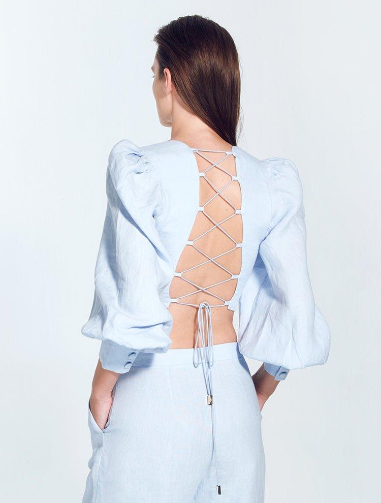 "Model showing back view of Eliana Baby Blue Top with adjustable lace-up back and button details"