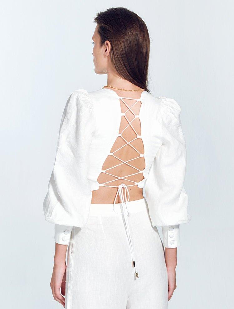 "Back view of model in Eliana White Top, featuring an adjustable lace-up back and covered buttons"