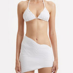 "Close-up of the Ephram white skirt's wavy texture detail and asymmetric hemline. The intricate texture creates a visually stunning pattern, adding an artistic flair to the skirt's elegant design."