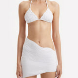 "Close-up of the Ephram white skirt's wavy texture detail and asymmetric hemline. The intricate texture creates a visually stunning pattern, adding an artistic flair to the skirt's elegant design."