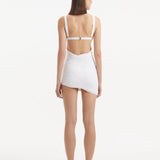 "Back view of the Ephram white high-waist asymmetric skirt, featuring the high-waisted design and unique asymmetric cut. The wavy texture detail adds visual depth and sophistication."