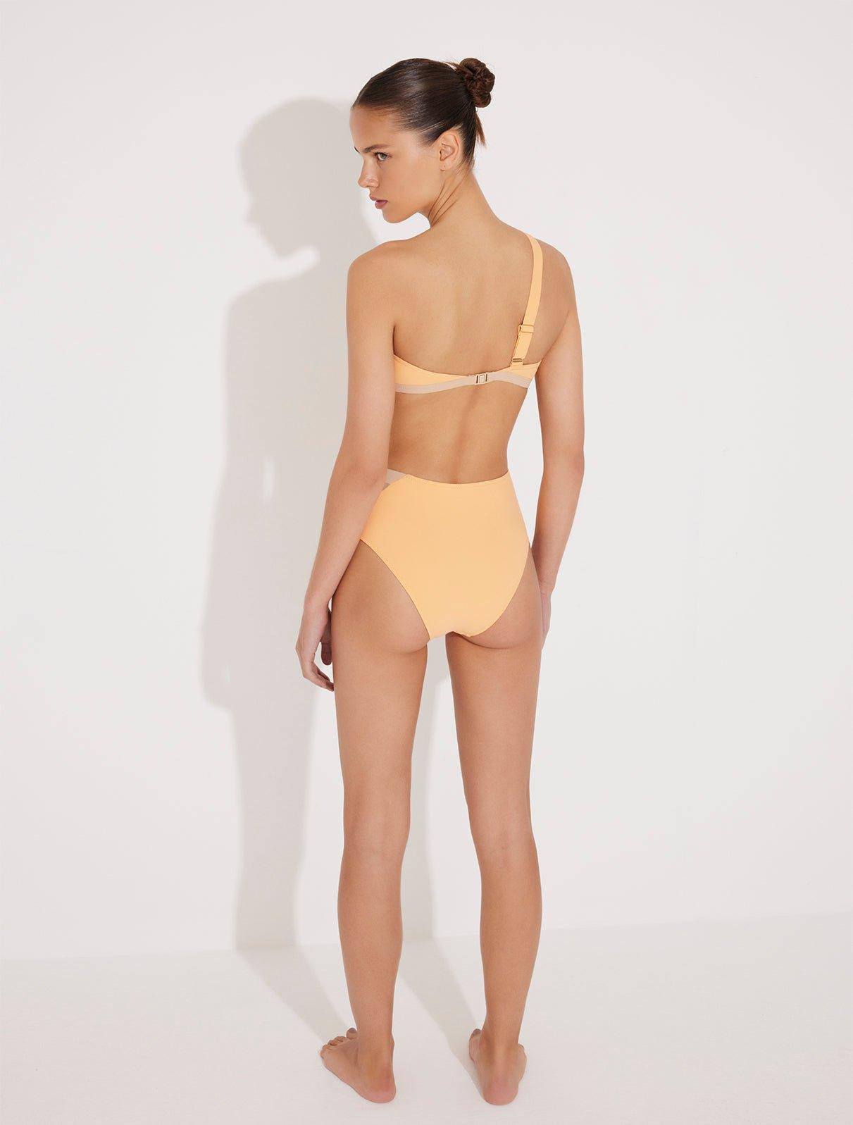 "Model wearing the Etta Orange/Nude One-Shoulder Bikini Top from the back, highlighting the single adjustable strap and mesh details. "