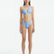 Model wearing the Eyre Baby Blue Bikini Bottom, highlighting the mid-rise design and shell-shaped gold button details.
