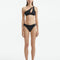 Model wearing the Eyre Black Bikini Bottom, highlighting the mid-rise hipster design and shell-shaped gold button details.