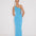 Front View: Model in Fewa Blue Dress - MOEVA Luxury Swimwear, One Shouldered Ready to Wear Dress, Gold Sculpted Hoop Accessory, Side Slit, MOEVA Luxury Swimwear