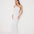 Front View: Model in Fewa White Dress - MOEVA Luxury Swimwear, One Shouldered Ready to Wear Dress, Gold Sculpted Hoop Accessory, Side Slit, MOEVA Luxury Swimwear