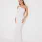 Front View: Model in Fewa White Dress - MOEVA Luxury Swimwear, One Shouldered Ready to Wear Dress, Gold Sculpted Hoop Accessory, Side Slit, MOEVA Luxury Swimwear