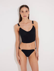 Front View: Model in Franca Black Bikini Bottom - MOEVA Luxury Swimwear, Low-Waist, Gold Rectangle Accessory, Moderate Bottom Coverage, MOEVA Luxury Swimwear  