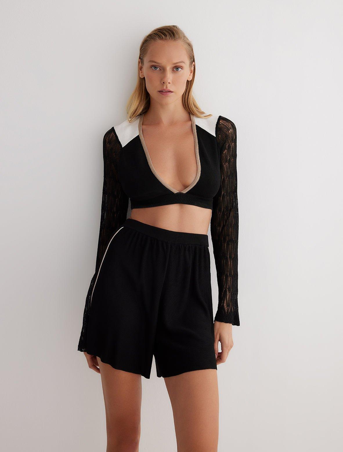 " Front view of high-waisted knitted shorts with semi-sheer panels and a sleek silhouette."