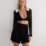 " Front view of high-waisted knitted shorts with semi-sheer panels and a sleek silhouette."