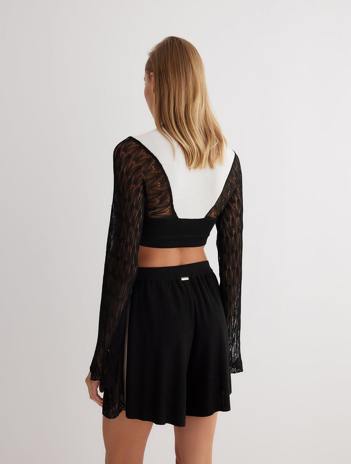 " Back view of high-waisted shorts with semi-sheer panels, featuring a sleek mid-thigh silhouette."