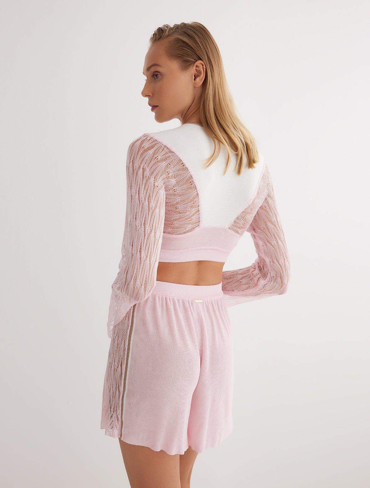 "Back view of high-waisted knitted shorts with semi-sheer details and a sleek mid-thigh length."