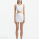 Front View: Model in Garda White Top and Jazero White Skirt - MOEVA Luxury Swimwear, High Neck, Bands At The Waist, Cut-outs At Side Seam, Open Back, Ready to Wear Top, MOEVA Luxury Swimwear