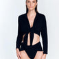 "Front view of a model in the Greta Shiny Black Shirt, displaying its cropped length and stylish design."