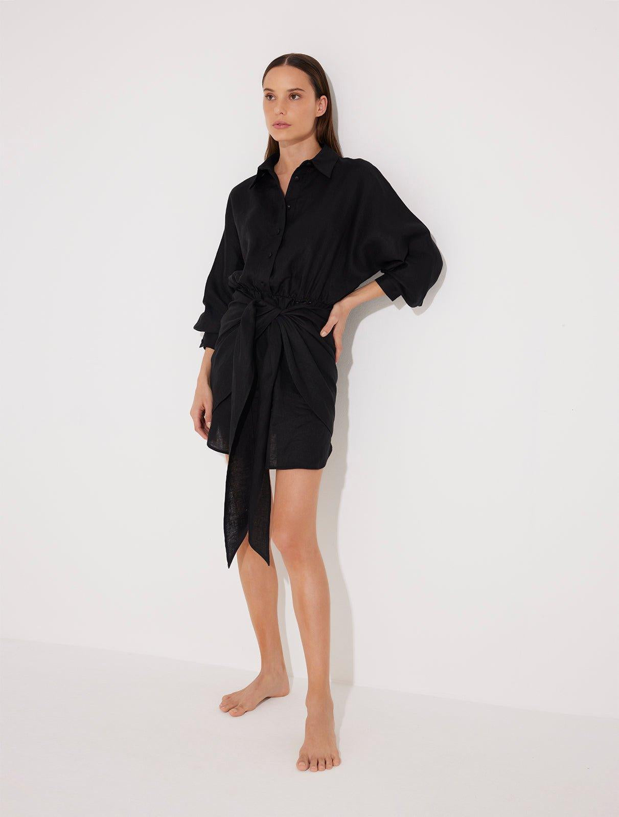 "Front view of a model in the Guadalupe Black Dress, showcasing its cinched waist and elegant silhouette."