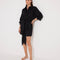 "Front view of a model in the Guadalupe Black Dress, showcasing its cinched waist and elegant silhouette."