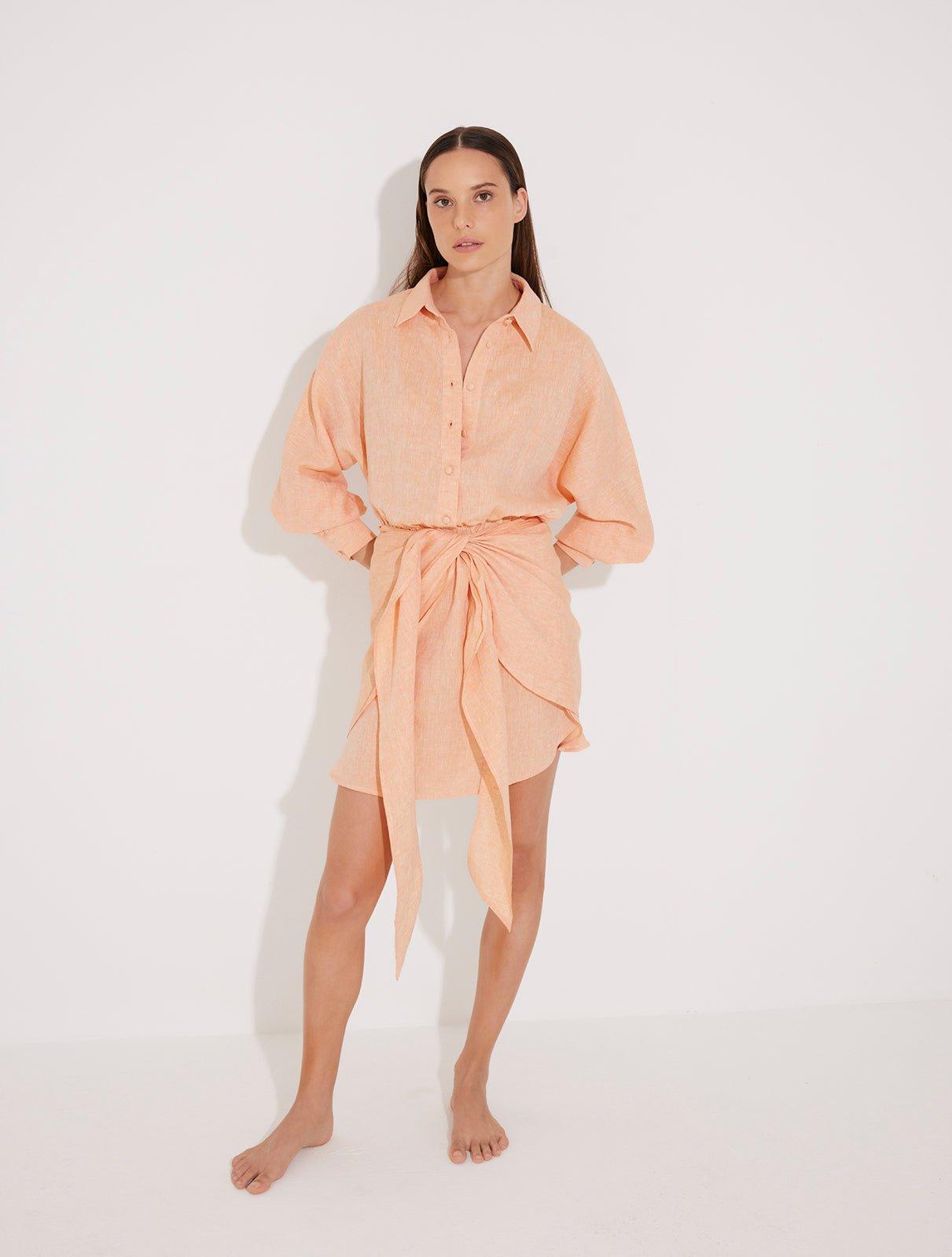"Front view of a model in the Guadalupe Orange Dress, showcasing its cinched waist and elegant silhouette."