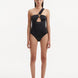 Model showcasing the Halin Black Swimsuit, highlighting the tie-neck design and gold sculpted accessory.