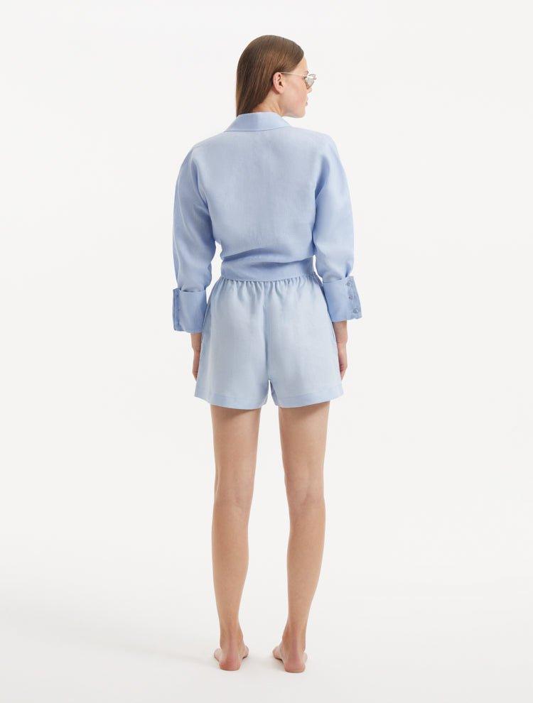 "Model wearing the Masha Baby Blue Shorts from the back, showcasing the high-waisted design, elasticated waistband, and the relaxed fit of the shorts. "