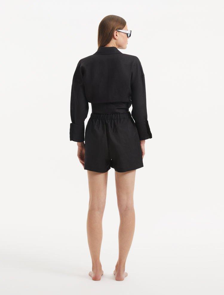 "Model wearing the Masha Black Shorts from the back, emphasizing the high-waisted cut and the relaxed, loose fit."