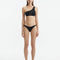"Model wearing the Harbor White Bikini Top, showcasing the one-shoulder design and geometric pattern."