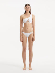 Model showcasing the Harbor White Bikini Bottom from the front, highlighting the geometric design and low waist fit.