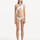 Model wearing Harbor White Bikini Set, showcasing the asymmetric one-shoulder top and mesh-inset bikini bottoms.