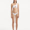 Model wearing the Harbor White Bikini Set from the front, showcasing the one-shoulder design and geometric pattern.