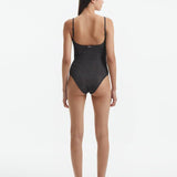 Back View: Model in Hartley Silver Swimsuit - Fully Lined, Metallic, Moderate Bottom Coverage, One Piece Swimsuit,  MOEVA Luxury Swimwear 