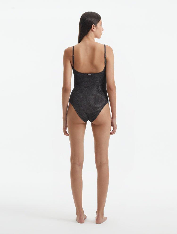 Back View: Model in Hartley Silver Swimsuit - Fully Lined, Metallic, Moderate Bottom Coverage, One Piece Swimsuit,  MOEVA Luxury Swimwear 