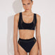 Front View: Model in Ilari Black Bikini Bottom - MOEVA Luxury Swimwear, Comfort and Sportive, High-Waist, High-Leg Silhouette, Mesh Details, Multicolor Option, MOEVA Luxury Swimwear  
