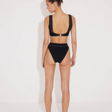 Back View: Model in Ilari Black Bikini Top - MOEVA Luxury Swimwear, Low Back, Gold Clasps at the Back, Multicolor Option, Lined, Italian Fabric, Special Lycra Xtralife Certificate, MOEVA Luxury Swimwear   