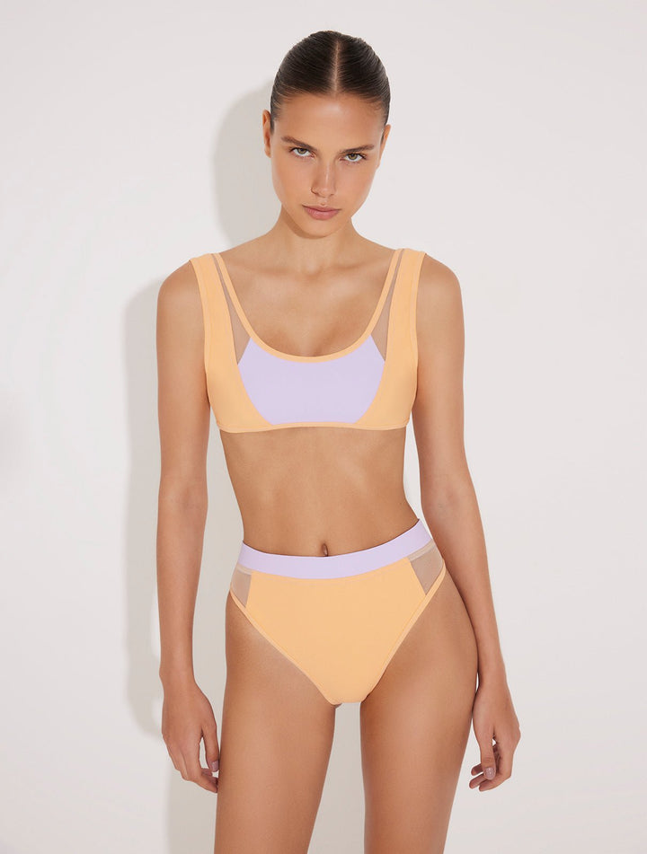Front View: Model in Ilari Orange/Lilac Bikini Bottom - MOEVA Luxury Swimwear, Comfort and Sportive, High-Waist, High-Leg Silhouette, Mesh Details, Multicolor Option, MOEVA Luxury Swimwear  