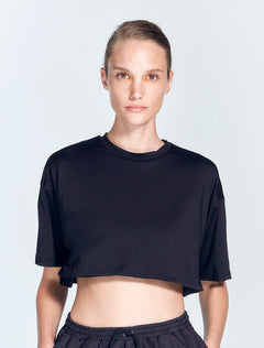 "Isolde Black Cropped Top front view showcasing its sporty and relaxed fit. The top features short sleeves and a cropped length, designed for comfort and ease during workouts."