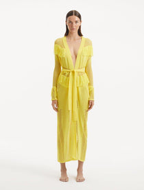 "Model showcasing the Itzel yellow kaftan from the front, highlighting its vibrant color, open-knit pattern, and dynamic fringed details that capture the essence of summer."