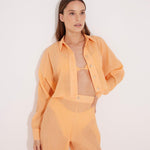 Jacinta Orange Cropped Sheer Long Sleeve Shirt | Moeva | Beachwear Tops | Each week unveils new pieces—luxury swimwear, fluid resort silhouettes, and elevated summer-to-evening essentials designed to carry you from coastal escapes to city nights.