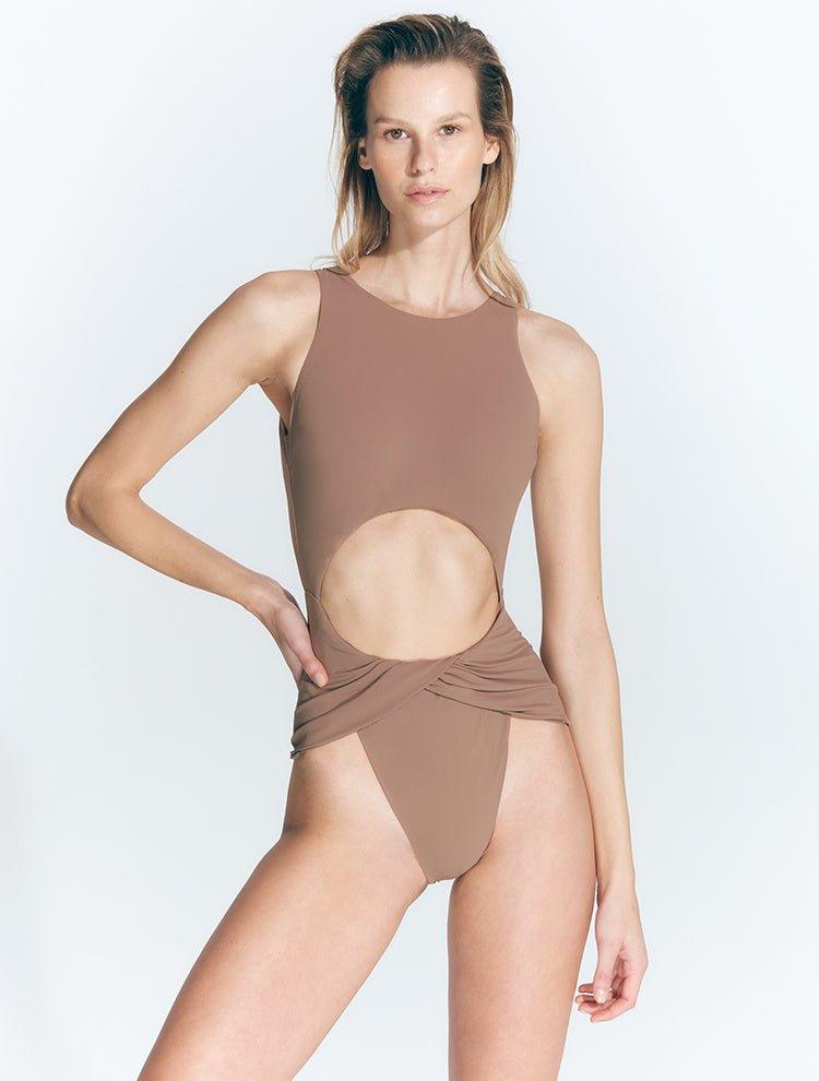 "Jackie Nude Swimsuit: High leg cut with twist knot front detail and high neckline, featuring an open back and gold-plated clasp closure."