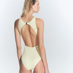 "Model wearing the Jackie Yellow Swimsuit from the back, highlighting the open back design and gold-plated clasp closure."