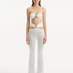 "Model wearing Jenna White Pants from the front, highlighting the high-waist, flared slim fit, and intricate cut-out details."