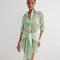 "Front view of the Jesabel Mint Green Dress, showcasing its mini shirt dress design with square patterned Broderie Anglaise cotton, button front, pointed collar, and waist-cinching tie."