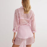 "Back view of the Jesabel Pink Dress, highlighting its mini length, button-down detail, and waist panel with a tie at the front."
