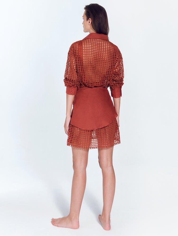 "Jesabel Red Ochre Mini Shirt Dress – Back View, showcasing the elegant Broderie Anglaise cotton fabric and waist panel with tie for a cinched silhouette."