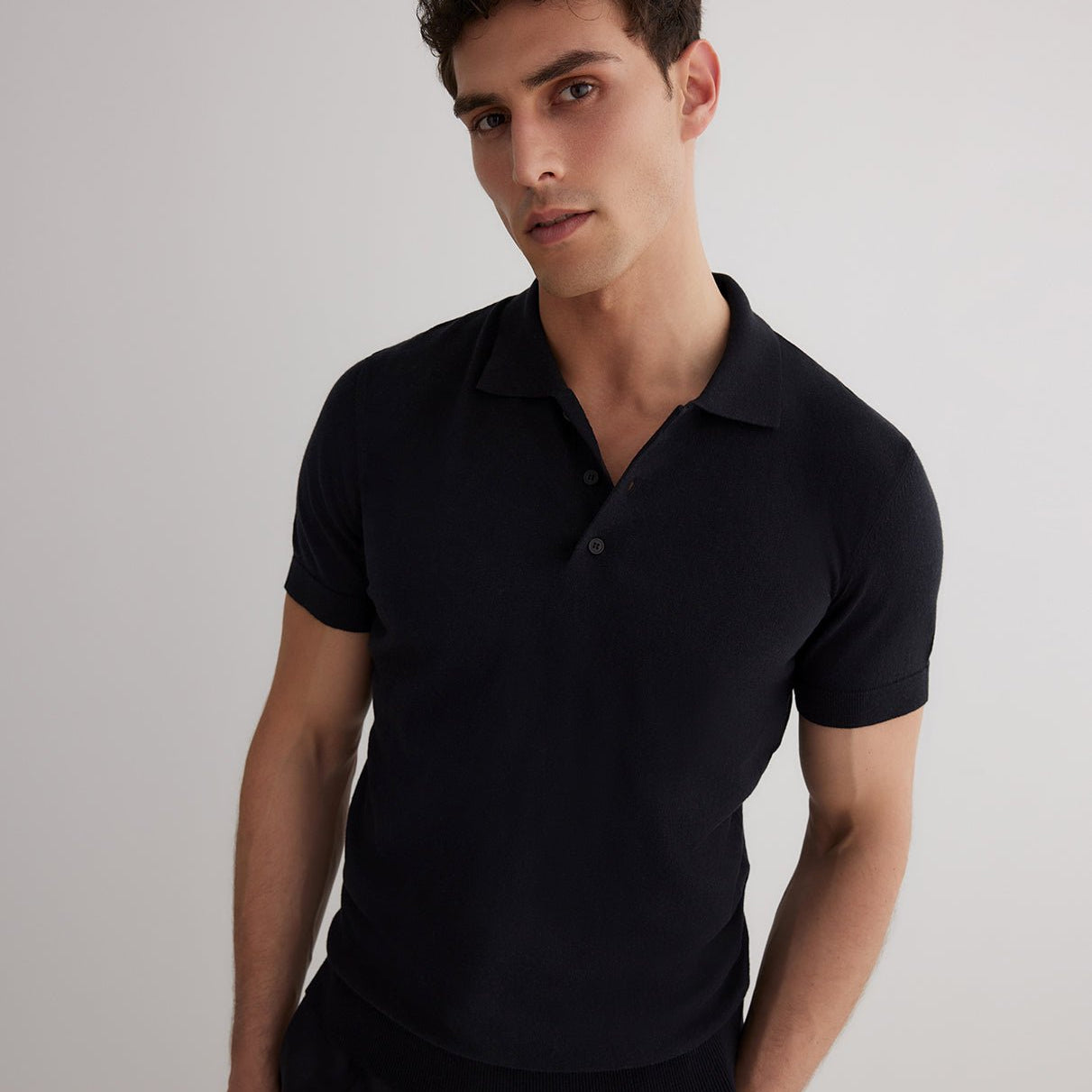 Front View: Model in Johan Black Polo Shirt - MOEVA Luxury Swimwear, Open Collar, Polo Shirt, Short-Sleeved, Cashmere & Cotton-Blend, Slim Fit, MOEVA Luxury Swimwear