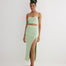 "Front view of a model in the Jules skirt, highlighting the elastic waistband and asymmetrical cut in mint green."